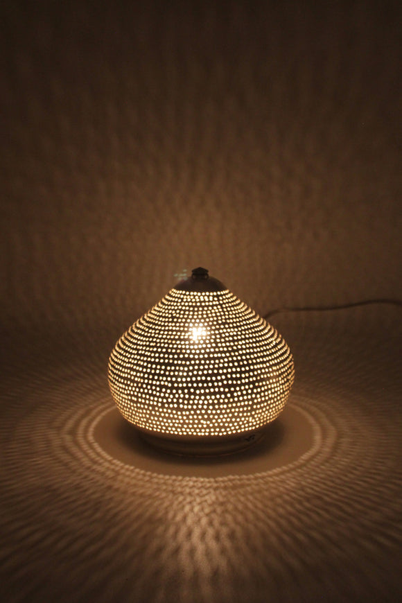 kleine gelochte Tischlampe aus Messing in Zwiebelform die beleuchtet einen schönen Schatten an die Wand zaubert