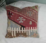 Anatolisches Vintagekissen mit graphischem Muster auf weissem Sofa