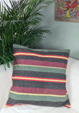 kelim mit blassen gruen-schwarz-roten Streifen auf weissem Sofa