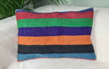 lila-orange-gruen gestreiftes Kilimcussion auf weissem Sofa