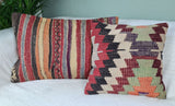 zwei Vintage-kelimkissen mit streifen und mustern auf sofa