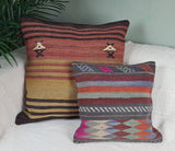 Zwei Kelimkissen mit streifen und Ornamenten auf weissem Sofa