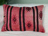 vintage kilimkissen in verwaschenem rot mit schwarzen streifen auf sofa