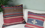 zwei Kelimkissen mit braun-roten Streifen auf weissem sofa