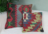 zwei Kilim mit zickzackmuster auf weissem Sofa