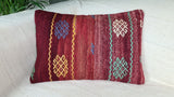 orientalisches Dekokissen in weinrot mit bunten Stickereien auf weissem Sofa