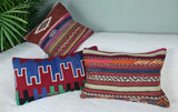 Drei Bunte Kilimkisssen mit kraeftigen Farben auf Sofa