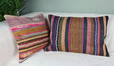 zwei orientalische Kilimcussion mit pinken elementen auf weissem Sofa