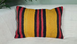 gelb-schwarz-rot gestreiftes dekokissen auf weissem Sofa