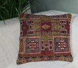 rot-gruen-gemustertes orientalisches dekokissen auf weissem sofa
