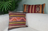 zwei alte Kilim mit rot-gelben streifen auf weissem Sofa