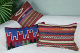Drei knallbunte Kilimkissen dekoriert auf weissem Sofa